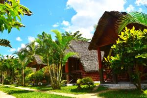 ein Haus mit Palmen davor in der Unterkunft Khair Lodge Ambanja in Ambanja