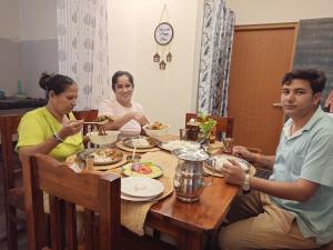a group of people sitting around a table eating food at Gaani Homestay Uttarkashi in Uttarkāshi