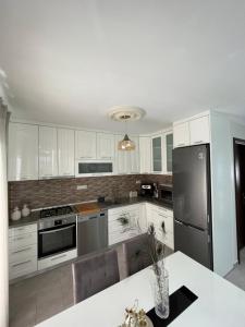 a kitchen with white cabinets and stainless steel appliances at Nikos Apartament in Prinos