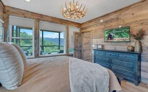 a bedroom with a bed and a tv and windows at Hang Yer Hat in Sevierville