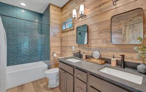 a bathroom with two sinks and a tub and a toilet at Hang Yer Hat in Sevierville +18 photos