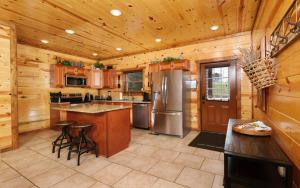 a large kitchen with wooden walls and wooden cabinets at Dip in the Smokies in Gatlinburg