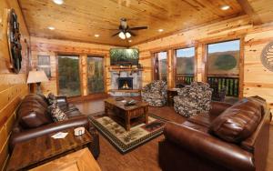 a living room with leather furniture and a fireplace at Dip in the Smokies in Gatlinburg