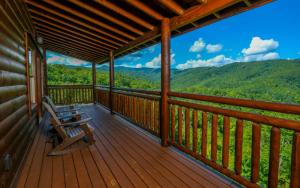 a porch with a bench and a view of the mountains at Dip in the Smokies in Gatlinburg