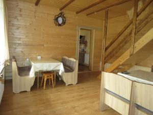 a dining room with a table and chairs in a cabin at Bilyy Kamin Guest House in Tatariv