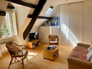 ein Wohnzimmer mit Couch und Fernseher in der Unterkunft Le Cocon - La Vue des Remparts- Historical center in Dinan