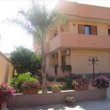a building with potted plants and a palm tree at Zahir da Cleo in Castro di Lecce