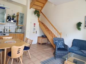 eine Küche und ein Wohnzimmer mit Tisch und Stühlen in der Unterkunft Haus am Park Whg 02 in Kühlungsborn