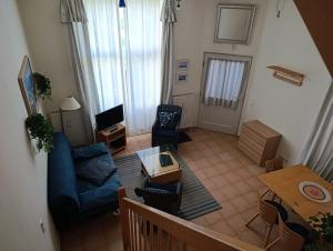 ein Wohnzimmer mit einem blauen Sofa und einem Tisch in der Unterkunft Haus am Park Whg 02 in Kühlungsborn