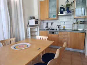 eine Küche mit einem Holztisch mit einem Teller darauf in der Unterkunft Haus am Park Whg 02 in Kühlungsborn + 5 Fotos