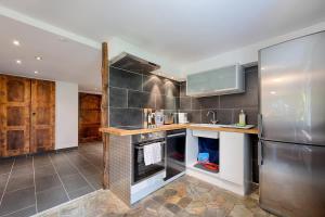ツェルマットにあるRiverside Apartmentのシンクと冷蔵庫付きのキッチン