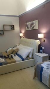 カターニアにあるCusmano Residenceのベッド、テーブル、ランプが備わるホテルルームです。