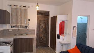 a kitchen with a wooden door and a sink at Nestabs Homes in Mtwapa +6 photos