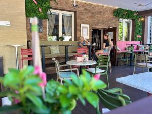 two women sitting at tables and chairs on a patio at Prenočišča Zvezda in Ljutomer