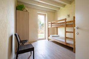 - une chambre avec des lits superposés, une chaise et une fenêtre dans l'établissement Luxury Villa on Garda Lake, à Soiano del Lago 42 autres photos