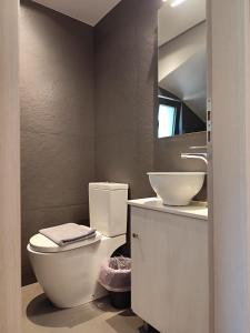 a bathroom with a white toilet and a sink at Tzouzos-Kordopateika villa in Prosilio, Kardamyli in Prosílion