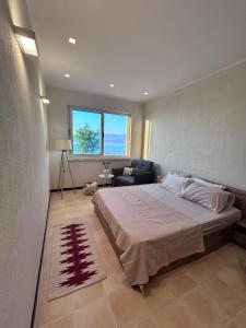 a bedroom with a bed and a couch and a window at Pelikan Lake House in Shkodër