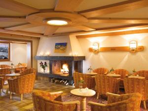 a restaurant with tables and chairs and a fireplace at Sporthotel Krone in Schoppernau