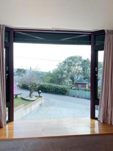 an open glass door with a view of a patio at Meishan Jiujiu Landscape B&B in Dongshan
