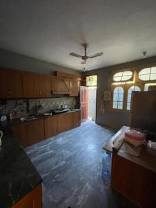a kitchen with wooden cabinets and a ceiling at Mountain Dale Guest House in Gilgit