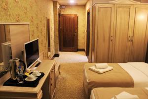 una camera d'albergo con letto e TV di Vendome Hotel a Eskişehir