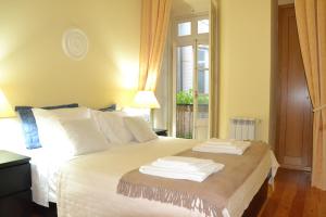 una camera da letto con un letto con lenzuola bianche e una finestra di Fantastic Downtown New Apartment a Lisbona