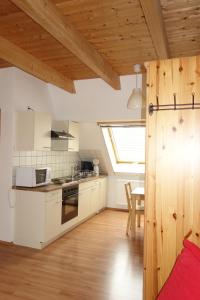 eine Küche mit weißen Schränken, einem Tisch und einem Fenster in der Unterkunft Bertelemühle in Günzburg