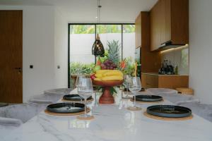 a table with wine glasses and a bowl of bananas on it at Modern 3BR Private Pool Villa 5-min Beach in Canggu