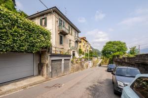 a street with cars parked on the side of a building at Appartamento Storico in Villa Anni '30 - Vicino al Centro Como in Como