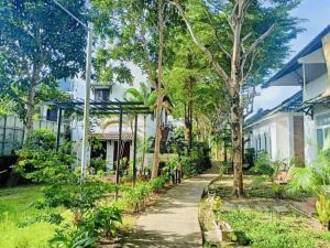 a walkway in front of a house with trees at Nos Vetra Resort in Phú Quốc