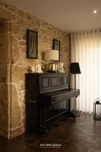 a piano in a room with a stone wall at Casa da Trapa in Oliveira de Azemeis +38 photos