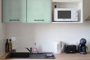 a kitchen counter with a sink and a microwave at Centre les sables - jet d'eau - T2 Grande Plage in Les Sables-dʼOlonne