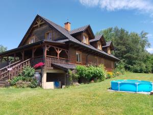 a large wooden house on a hill with a yard at ORLIK - pokoje gościnne in Uście Gorlickie