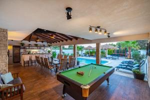 ein Wohnzimmer mit einem Billardtisch und einem Pool in der Unterkunft Villa Andrea ZadarVillas in Zaton