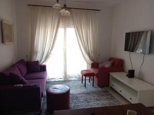 ein Wohnzimmer mit einem lila Sofa und einem Fenster in der Unterkunft Lime-apart in Tivat