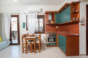 a kitchen with green cabinets and a table and chairs at Cozy apartment in Polychrono in Polychrono