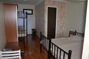 a bedroom with a bed and a wooden floor at TJ Guest House in Makhinjauri