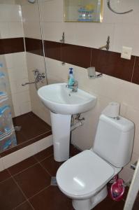 a bathroom with a white sink and a toilet at TJ Guest House in Makhinjauri +81 photos