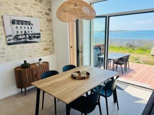 una sala da pranzo con tavolo e vista sull'oceano di Le Spa sur la dune, Santec, Bretagne a Santec