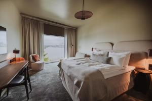 una camera da letto con un letto, una scrivania e una finestra di Clarion Hotel The Pier a Göteborg Altre 37 foto