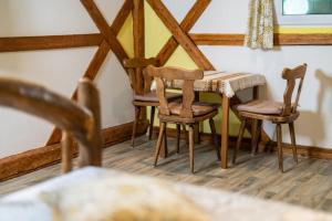 a table and chairs in a room with wooden floors at Sobe na skednju in Bohinjska Bistrica