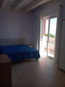 ein Schlafzimmer mit einem blauen Bett und einer Glasschiebetür in der Unterkunft Arold Casa Vacanze in Francavilla al Mare