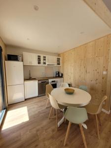 eine Küche und ein Esszimmer mit Tisch und Stühlen in der Unterkunft Maison bord du Lac des Settons in Montsauche-les-Settons