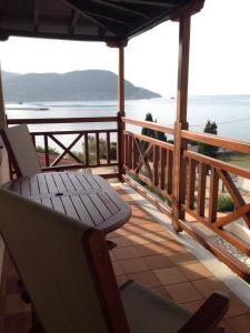 porche con banco y vistas al agua en Pleoussa Studio and Apartments, en Skopelos Town