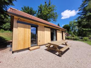 eine Holzhütte mit einem Picknicktisch und einer Bank in der Unterkunft Maison bord du Lac des Settons in Montsauche-les-Settons + 18 Fotos
