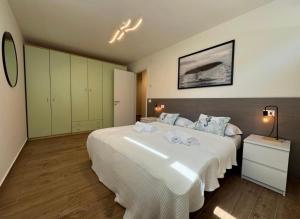 a bedroom with a large white bed with towels on it at Villa Pinewood in Lignano Sabbiadoro