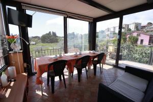 a dining room with a table and chairs and a large window at la circumetnea rooms in Catania
