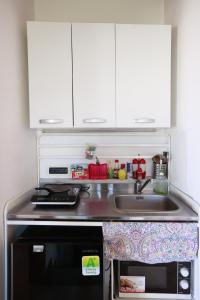 a kitchen counter with a sink and a microwave at la circumetnea rooms in Catania