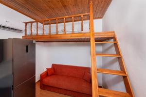 a loft bed in a room with a red couch at PARADISE SEA HOUSE a in Haraki