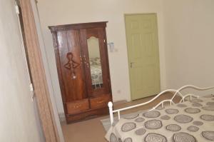 ein Schlafzimmer mit einem Bett, einer Kommode und einem Spiegel in der Unterkunft Torobali IMMO Apartment 4- Modern 1BDR- Near Embassies and Restaurants- Secure Building in Bamako